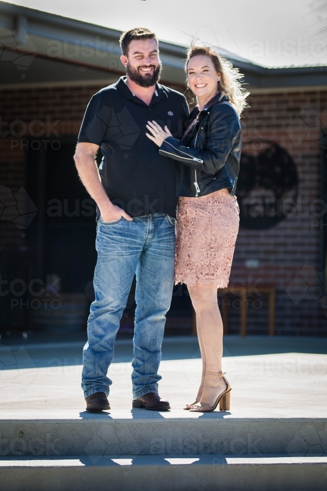 Husband and wife standing on steps at home - Australian Stock Image