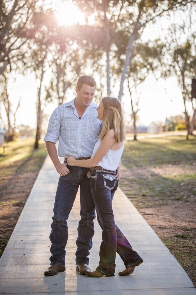 Husband and wife standing with arms around each other looking in eyes - Australian Stock Image