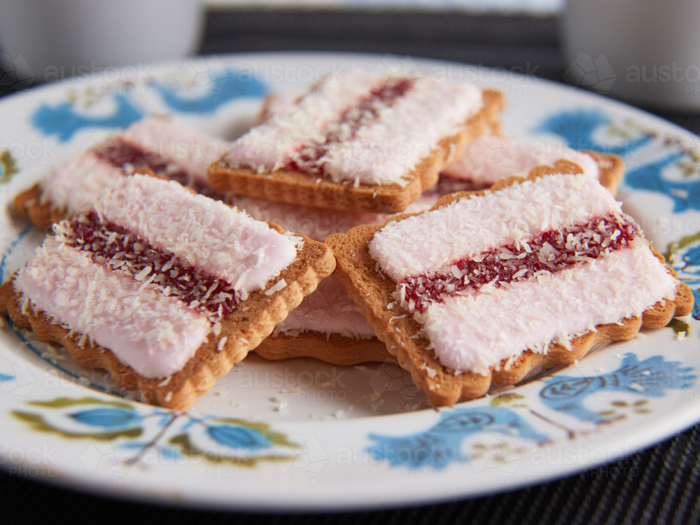 Iced Vo Vo biscuits on a plate with cups in background - Australian Stock Image