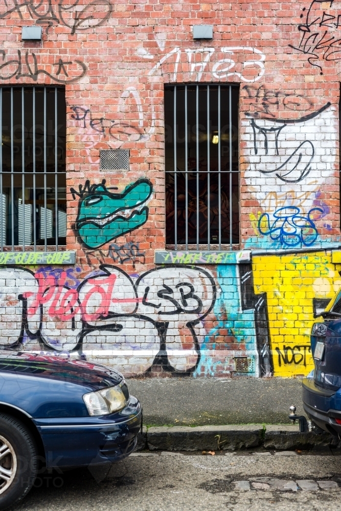 iconic suburb of Fitzroy, Melbourne, with graffiti covered old buildings - Australian Stock Image