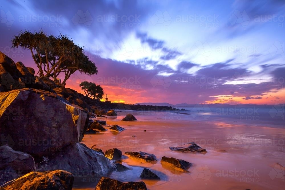 Incredible colourful sunset at Byron Bay over the water - Australian Stock Image