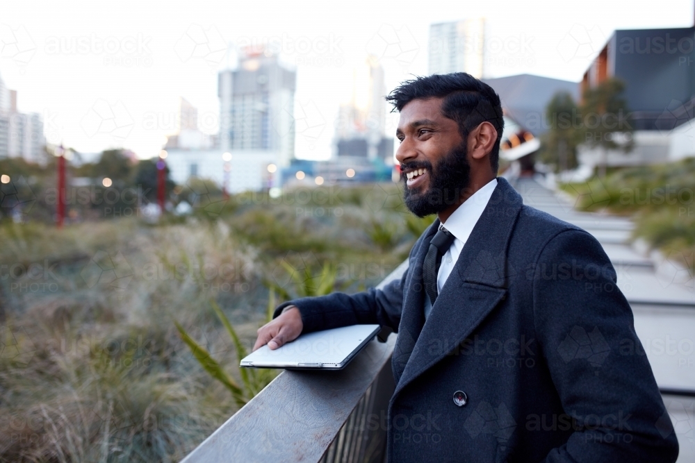 Indian architect with device surveying site - Australian Stock Image