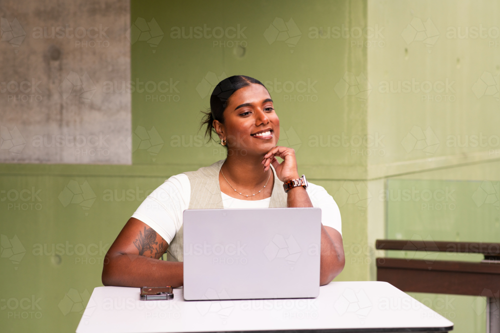 indian business woman in office setting with laptop - Australian Stock Image