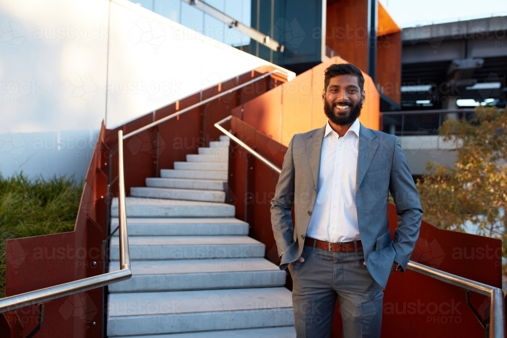 Indian businessman with open collar cheerful outdoors in city - Australian Stock Image
