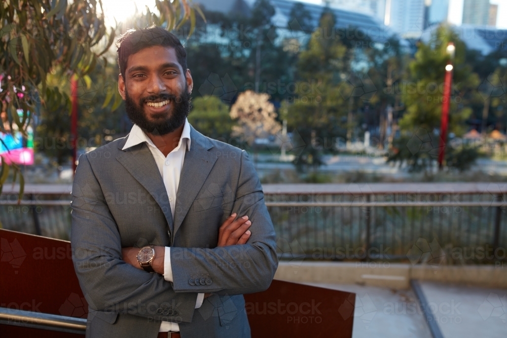 Indian businessman with open collar cheerful outdoors in city - Australian Stock Image