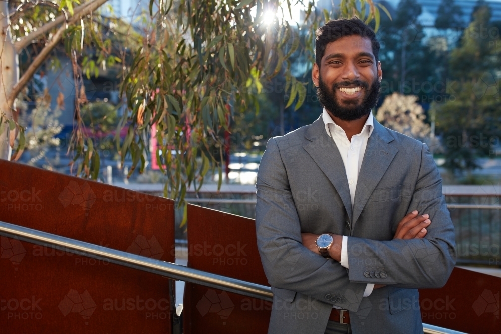 Indian businessman with open collar cheerful outdoors in city - Australian Stock Image
