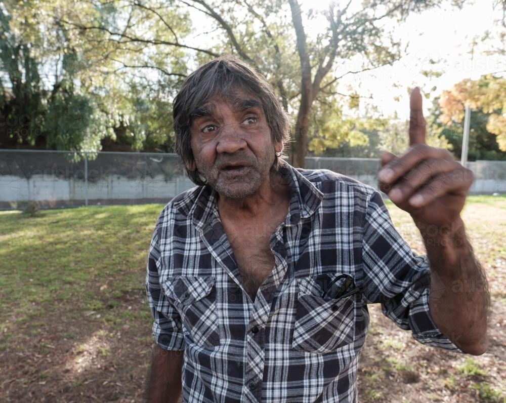 Indigenous Australian Man Outdoors with Finger Pointing Upwards - Australian Stock Image