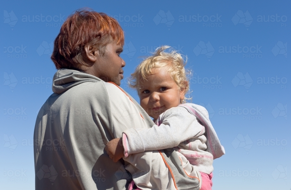 Indigenous Australian woman holding young child - Australian Stock Image