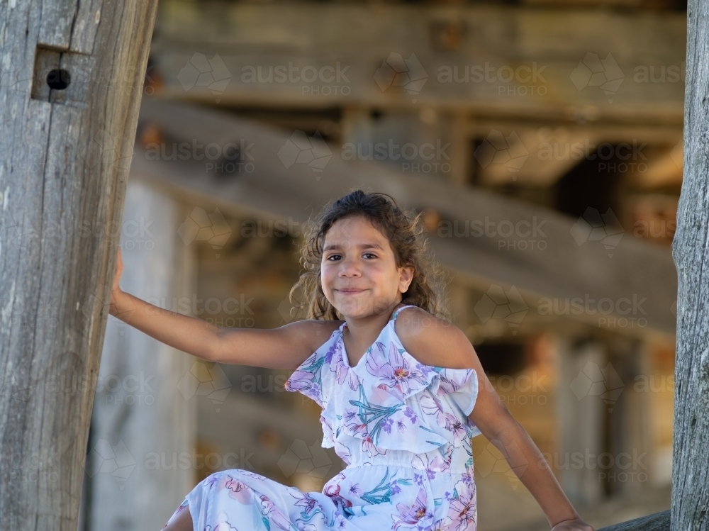 Indigenous girl inside an empty wooden barn - Australian Stock Image
