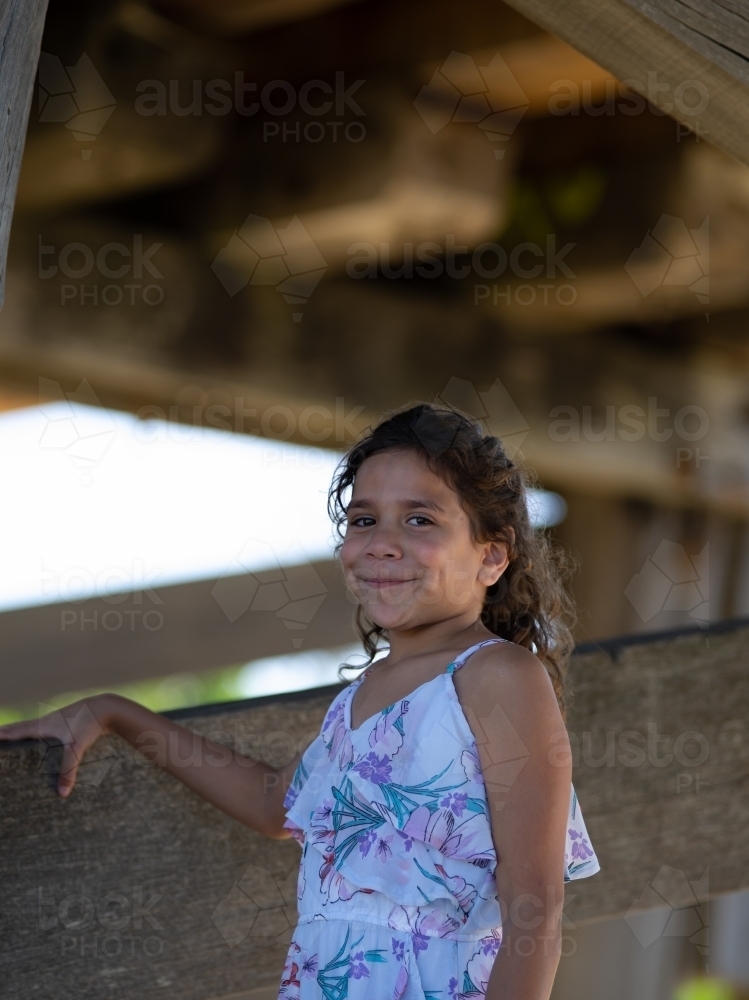 Indigenous girl inside an empty wooden barn - Australian Stock Image