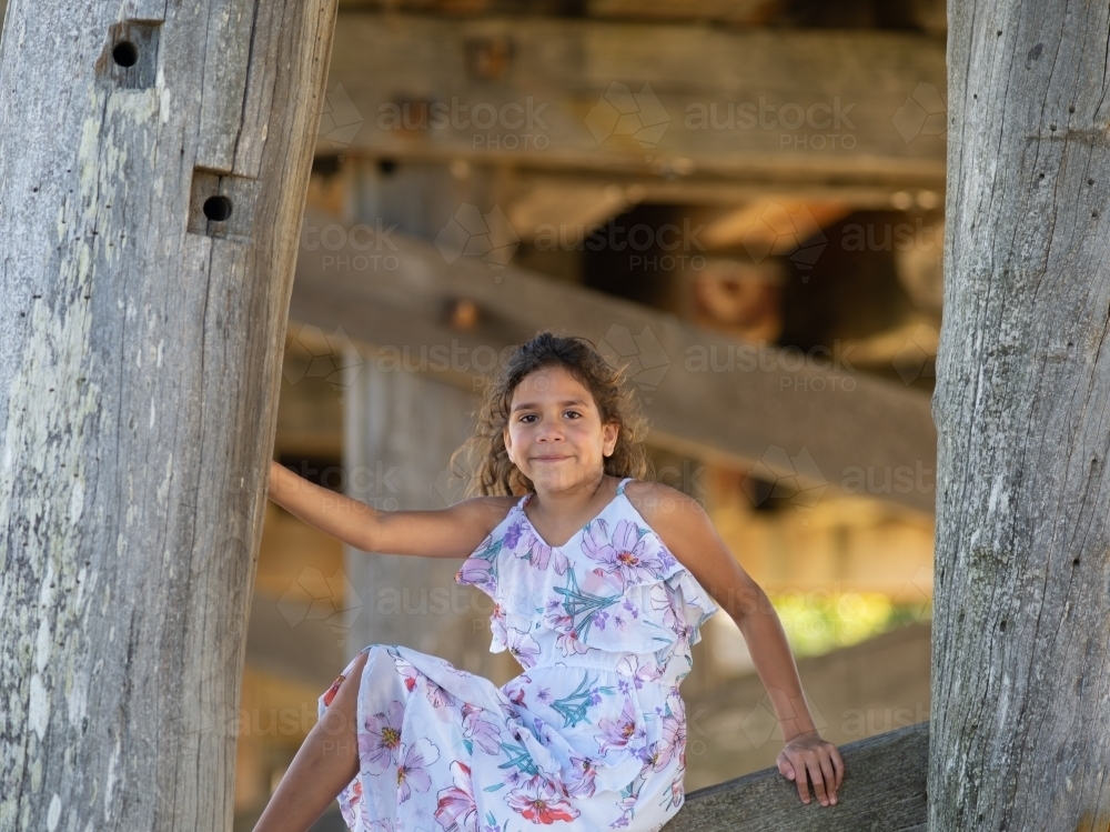 Indigenous girl inside an empty wooden barn - Australian Stock Image