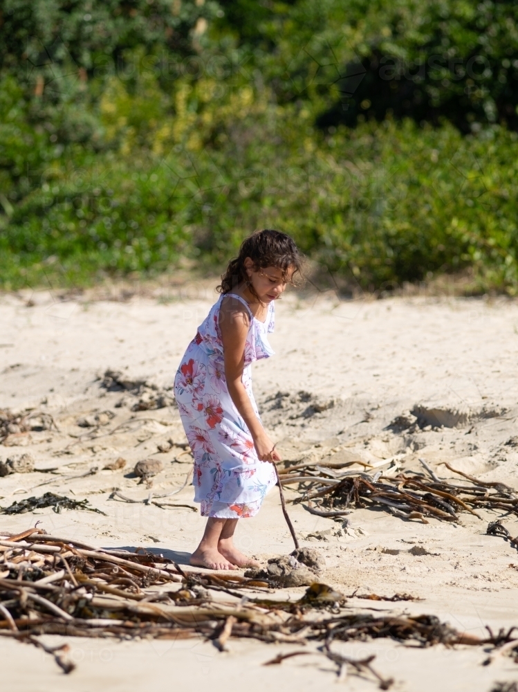 Indigenous girl playing in the sand - Australian Stock Image