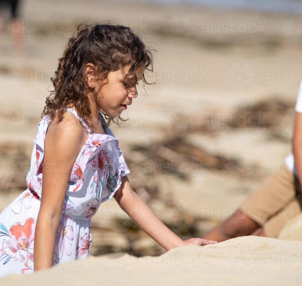 Indigenous girl playing in the sand - Australian Stock Image