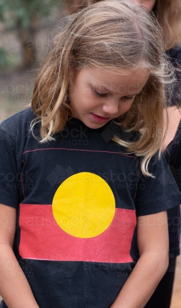 Indigenous girl standing looking down - Australian Stock Image