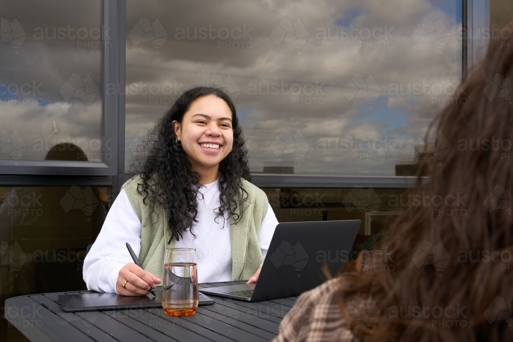 Indigenous woman studying with friend at home - Australian Stock Image