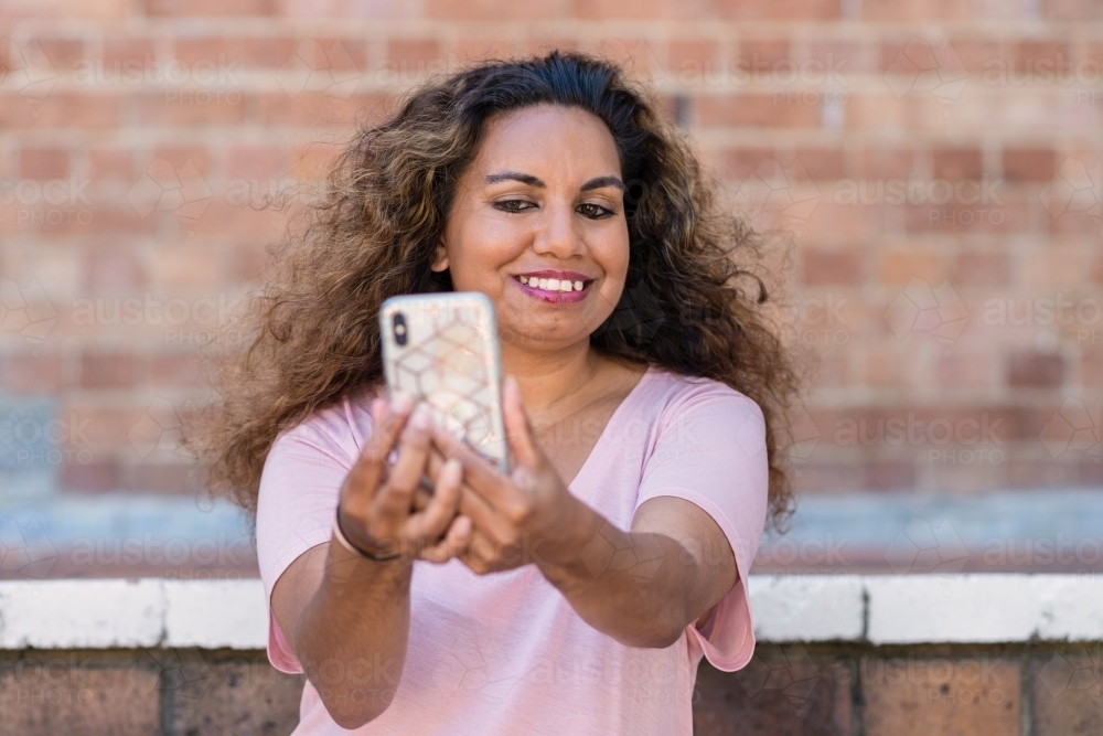 indigenous woman taking selfie with mobile phone - Australian Stock Image