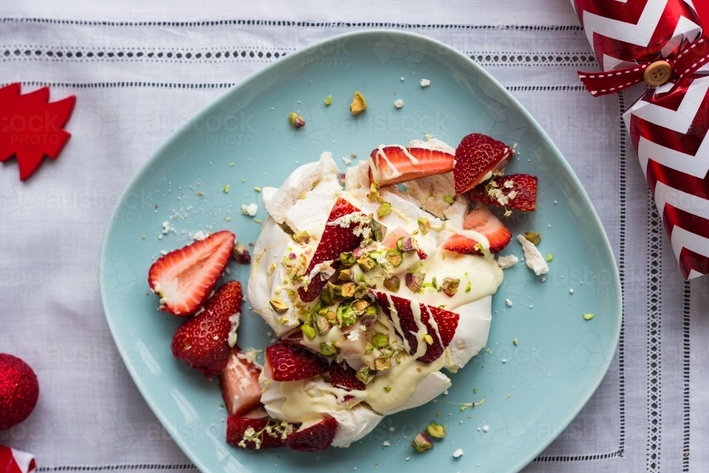 Individual dessert for christmas, a smashed meringue topped with cream, strawberries, pistachio - Australian Stock Image