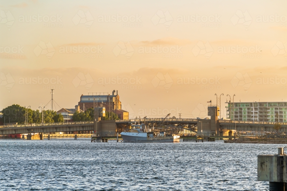 Industrial area of Port Adelaide with a fish boat and the Birkenhead Bridge across the Port River - Australian Stock Image