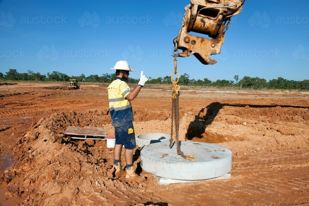 Industrial worker overseeing heavy machinery on a building site - Australian Stock Image