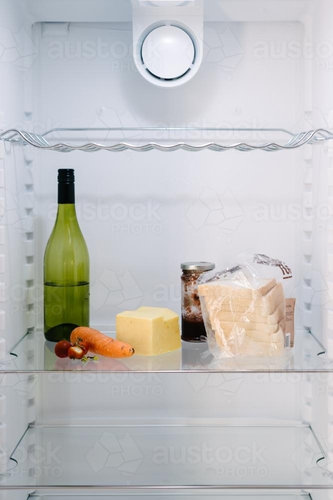 inside the fridge, a sad collection of mouldy food, bread, pickles and wine - Australian Stock Image