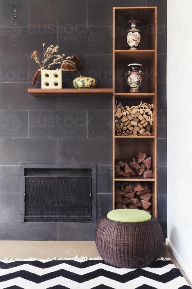 Interior designed living room nook of decor details, fireplace, wood, rug and ottoman - Australian Stock Image