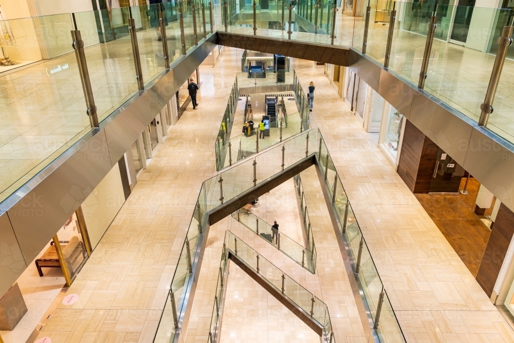 Interior view of a multi levelled shopping centre with glass barriers - Australian Stock Image
