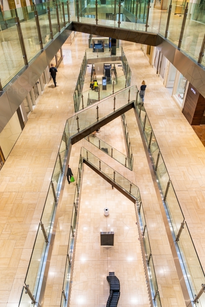 Interior view of a multi levelled shopping centre with glass barriers - Australian Stock Image