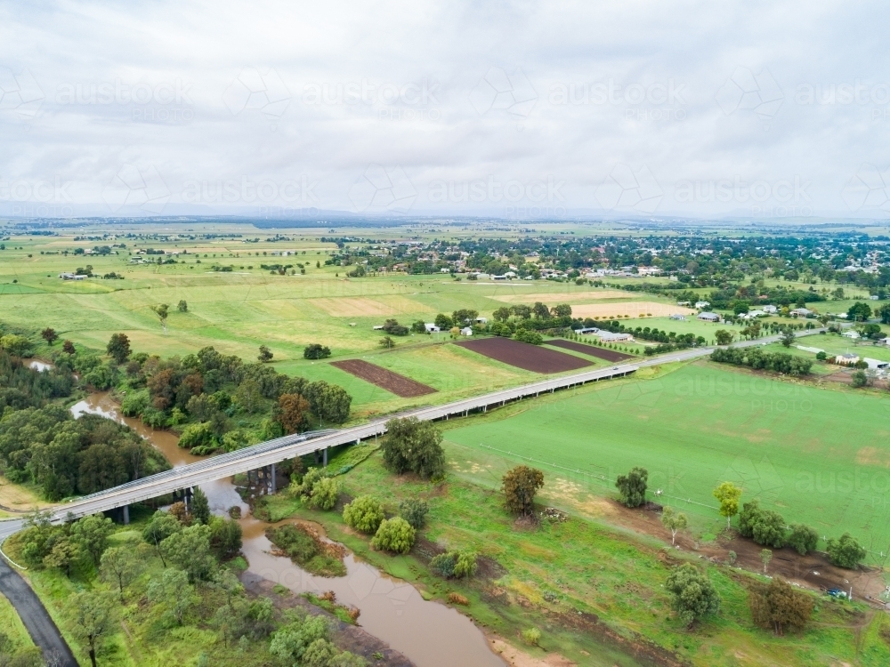 Image of Intersection of country roads going to bridge towards town of ...