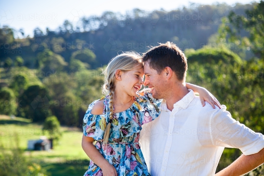 Intimacy or father and daughter looking at one another smiling outside on farm - Australian Stock Image