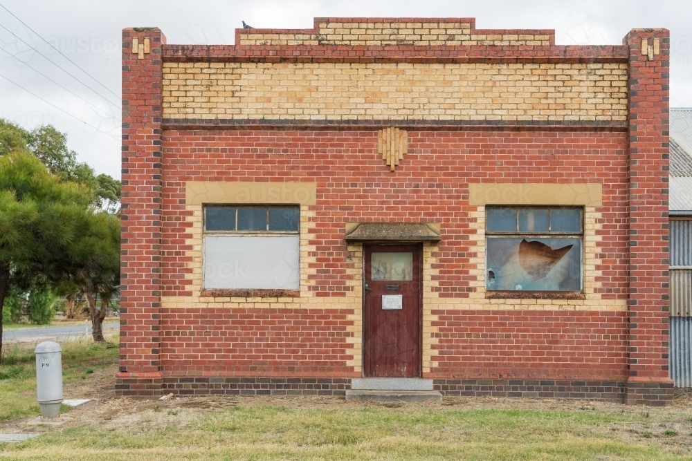 Intricate brickwork on the facade of an abandoned historic building on a street corner - Australian Stock Image
