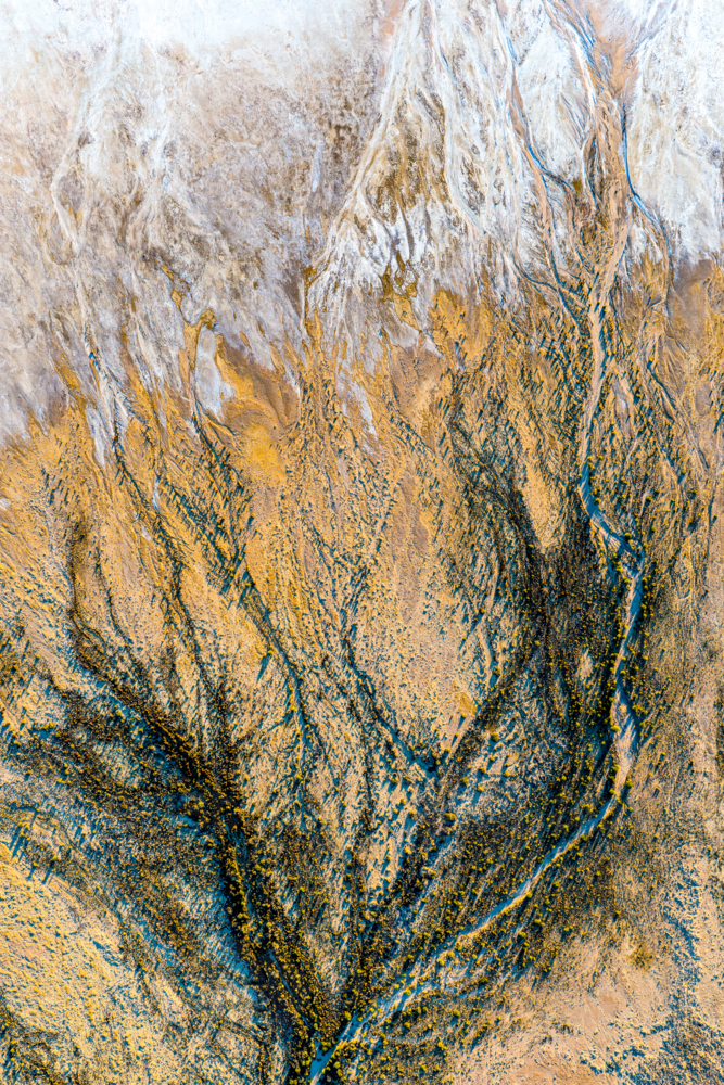 Intricate dark blue and golden erosion channels spread like veins across a textured salt pan - Australian Stock Image