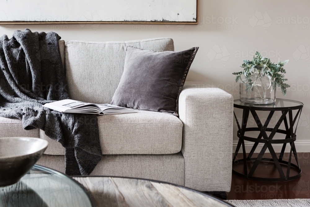 Inviting comfortable sofa with throw rug and magazine - Australian Stock Image