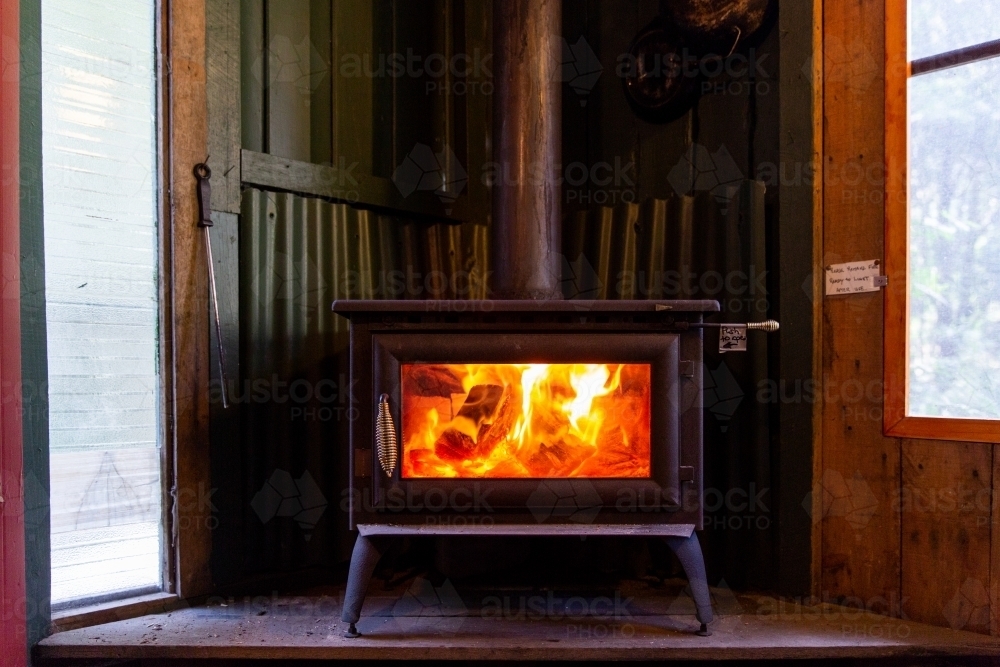 Inviting fireplace in rustic cabin on a cold winters day - Australian Stock Image
