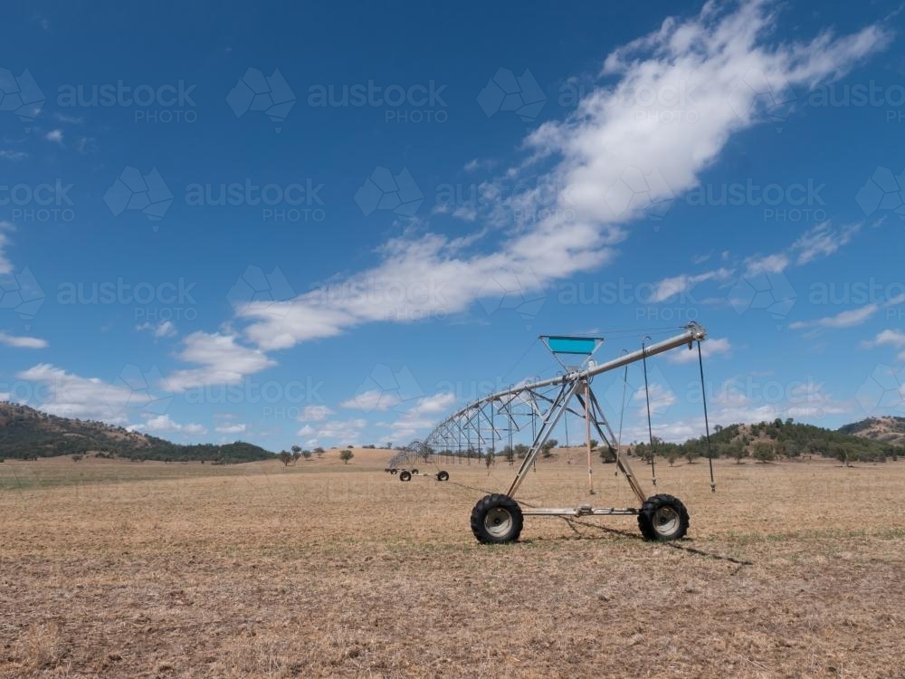 Irrigation spray system on dry summer paddock - Australian Stock Image