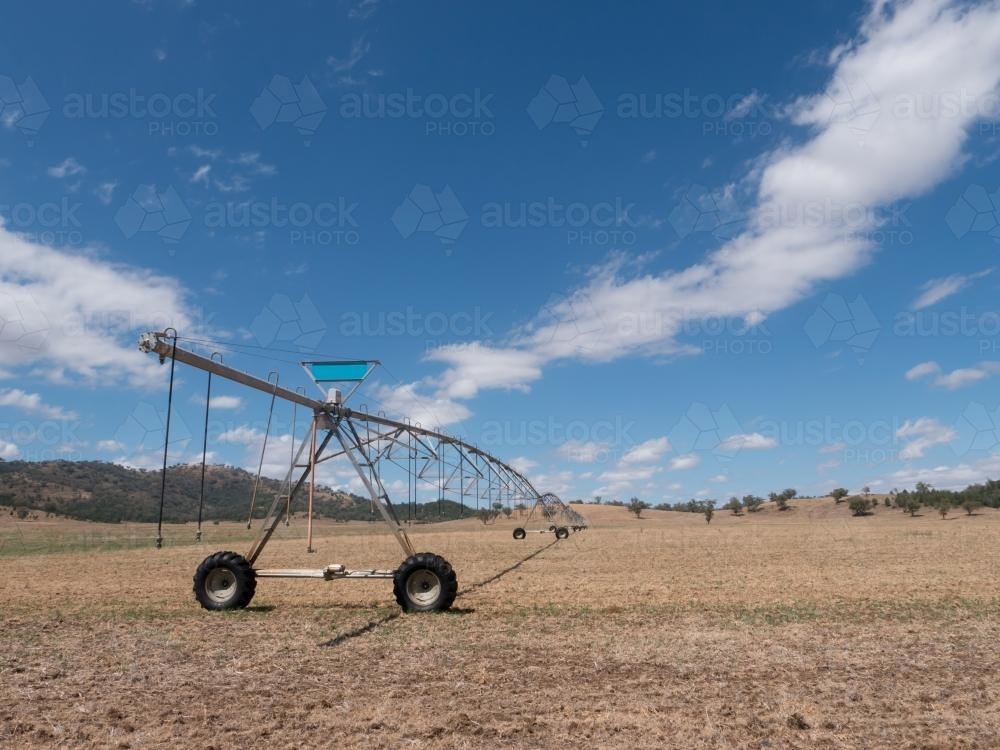 Irrigation spray system on dry summer paddock - Australian Stock Image