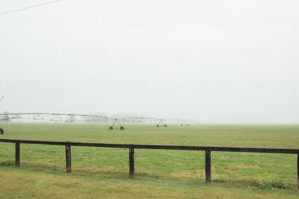 Irrigation system in a foggy paddock - Australian Stock Image