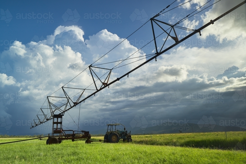 Irrigator sitting in paddock with storm clouds  behind. - Australian Stock Image