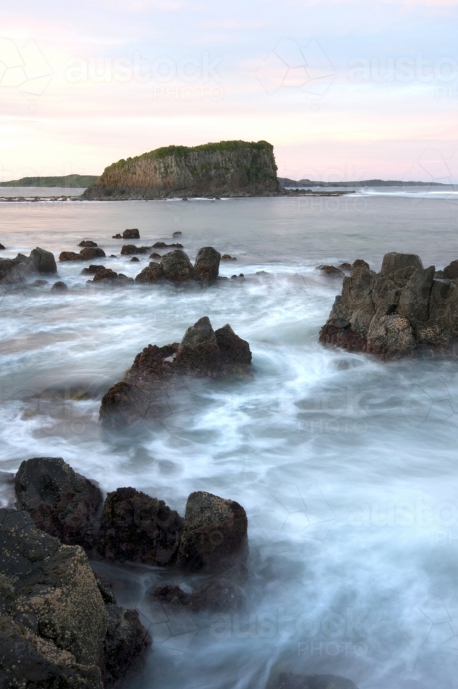 Island and blurred wave motion around rocks - Australian Stock Image