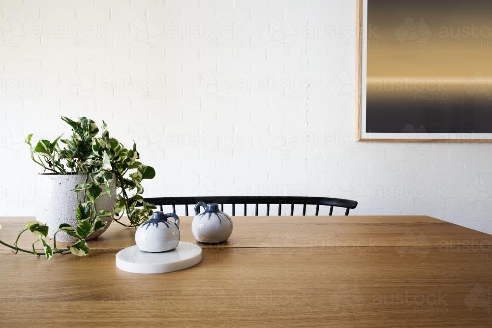 Ivy pot plant on table and white brick wall in dining room - Australian Stock Image