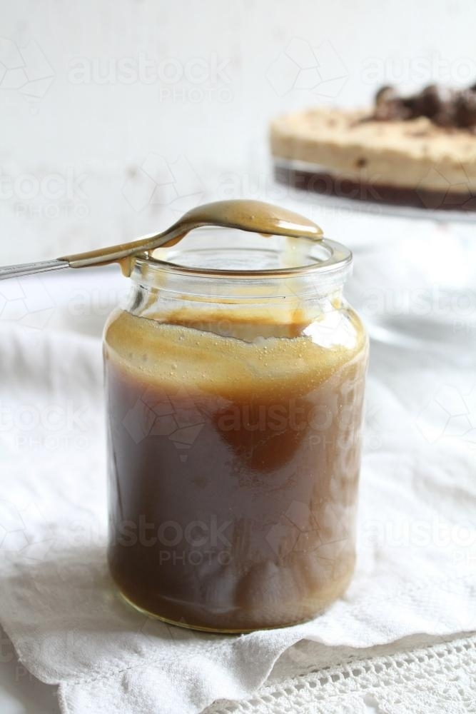 Jar of caramel sauce with spoon - Australian Stock Image