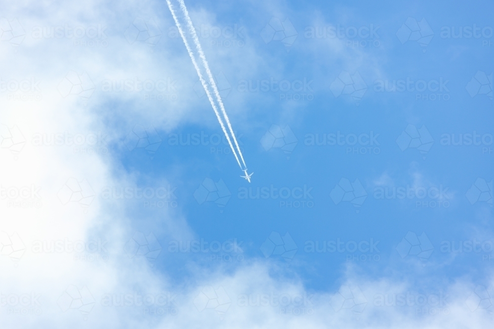 jet and contrails against blue sky - Australian Stock Image