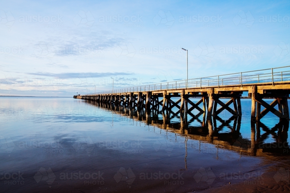 jetty and reflection in calm water - Australian Stock Image