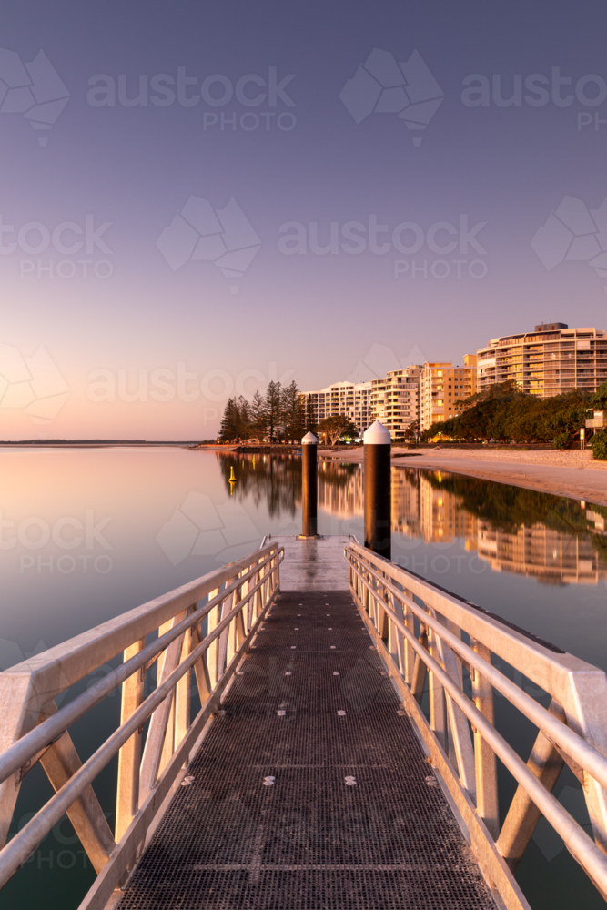 Jetty at Sunrise with Waterfront Apartments and Reflections - Australian Stock Image