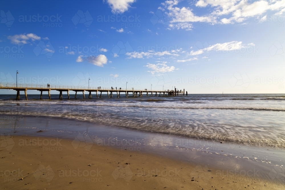 Jetty in late afternoon with waves lapping shore - Australian Stock Image
