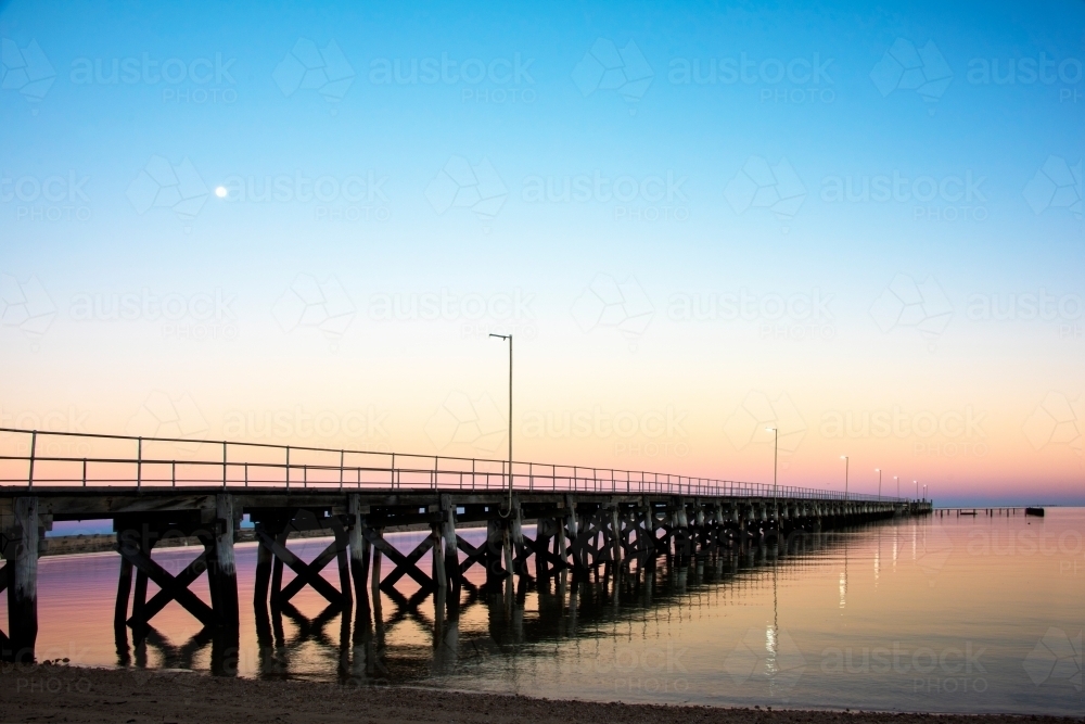 Jetty leading off into ocean at sunrise - Australian Stock Image