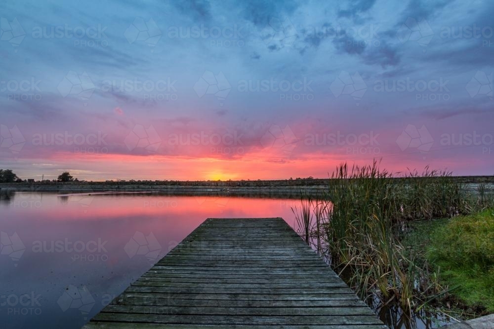 Jetty leading to colourful sunrise - Australian Stock Image