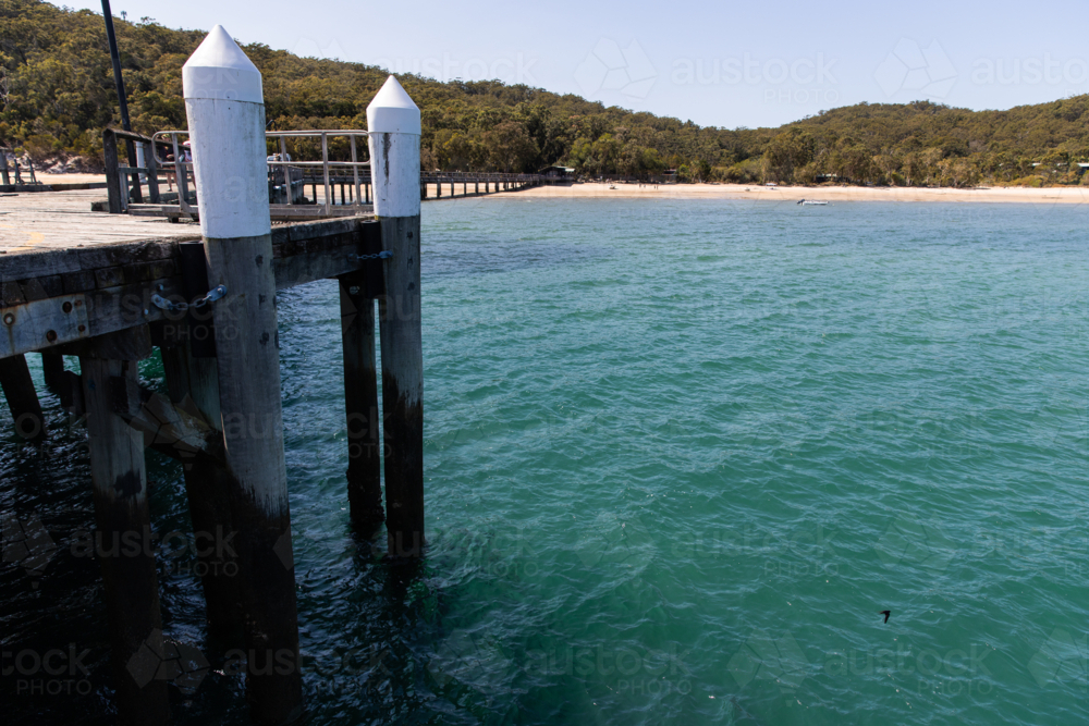 jetty pylons in turquoise water near Kingfisher Bay - Australian Stock Image