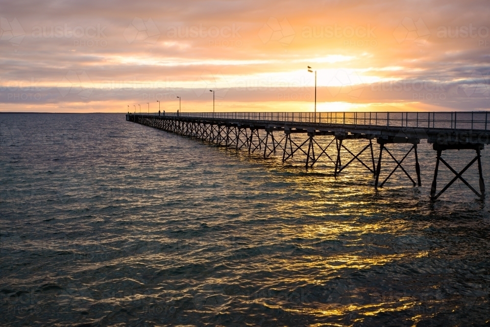 Jetty silhouetted against sunset - Australian Stock Image