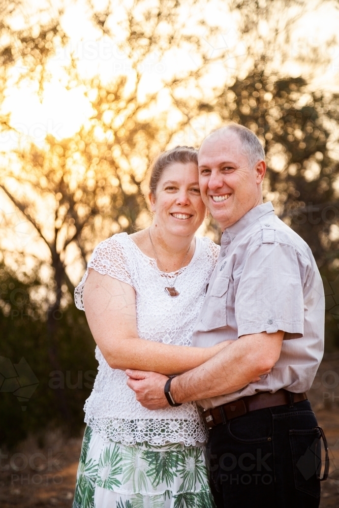 Joyful middle aged couple standing together in afternoon light - faithfulness - Australian Stock Image