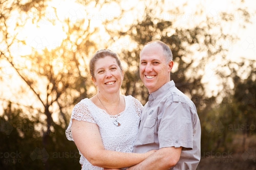 Joyful middle aged couple standing together in afternoon light - faithfulness - Australian Stock Image